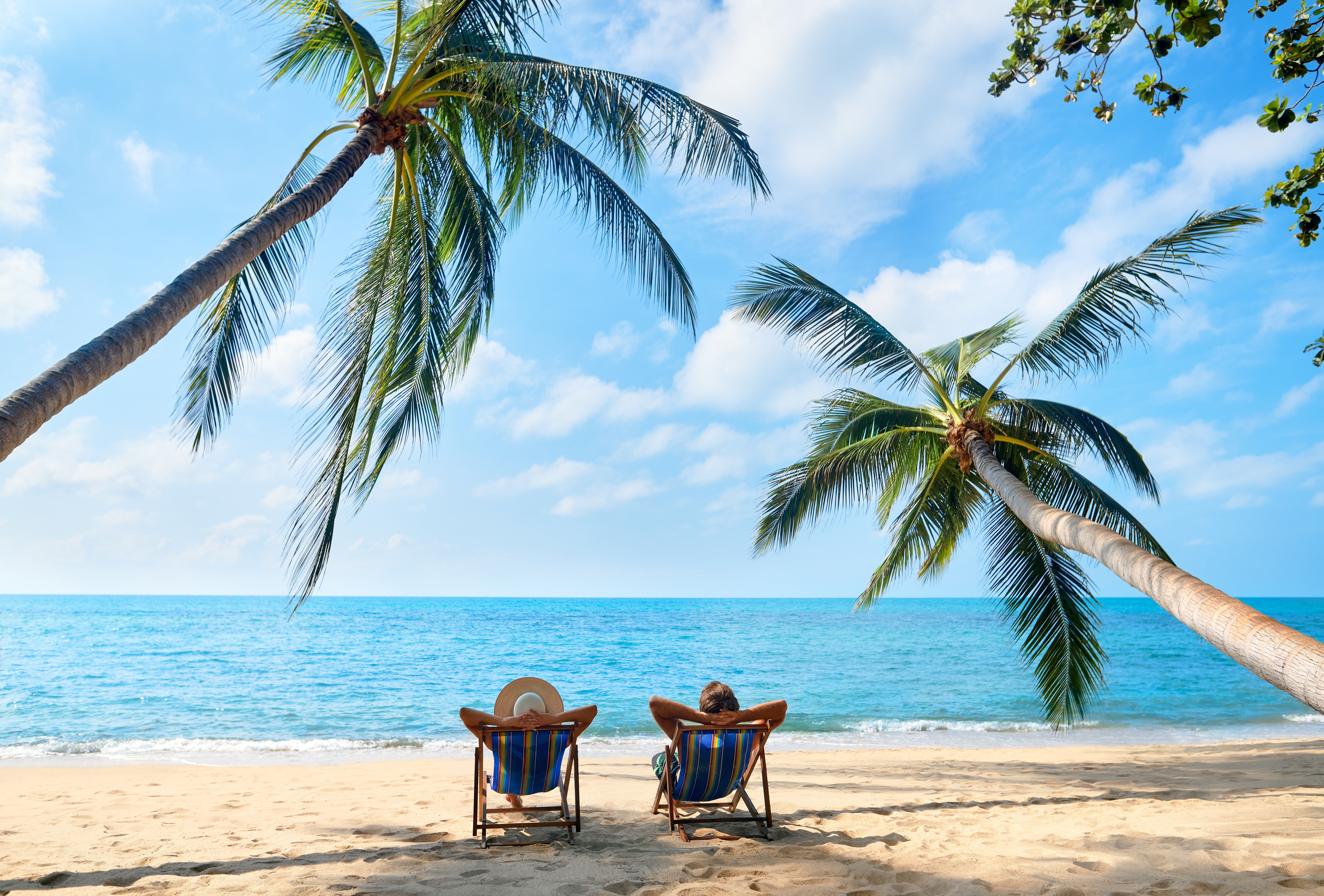 Couple relaxing on a beach with white sand and blue water