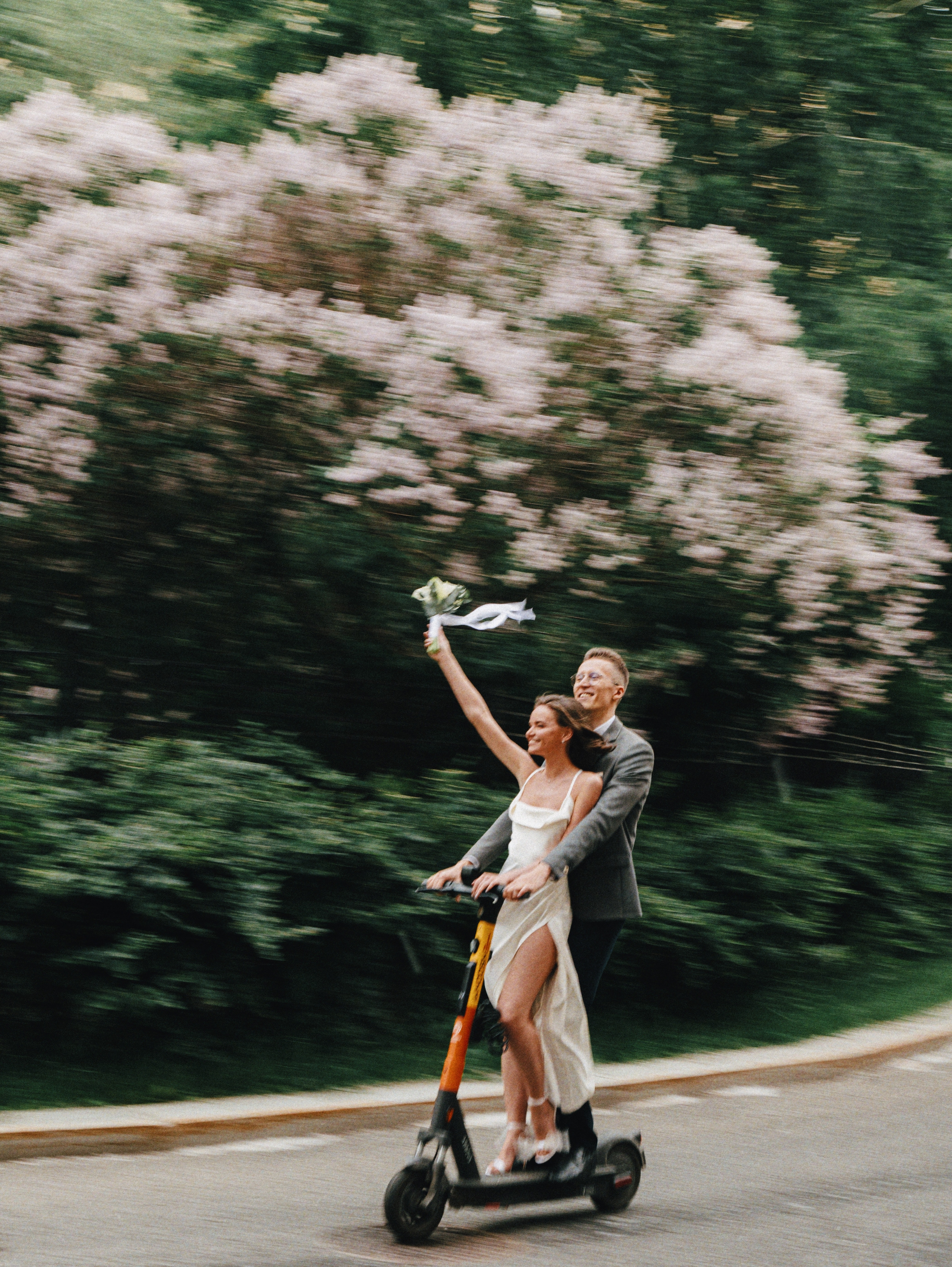 wedding couple riding a scooter together