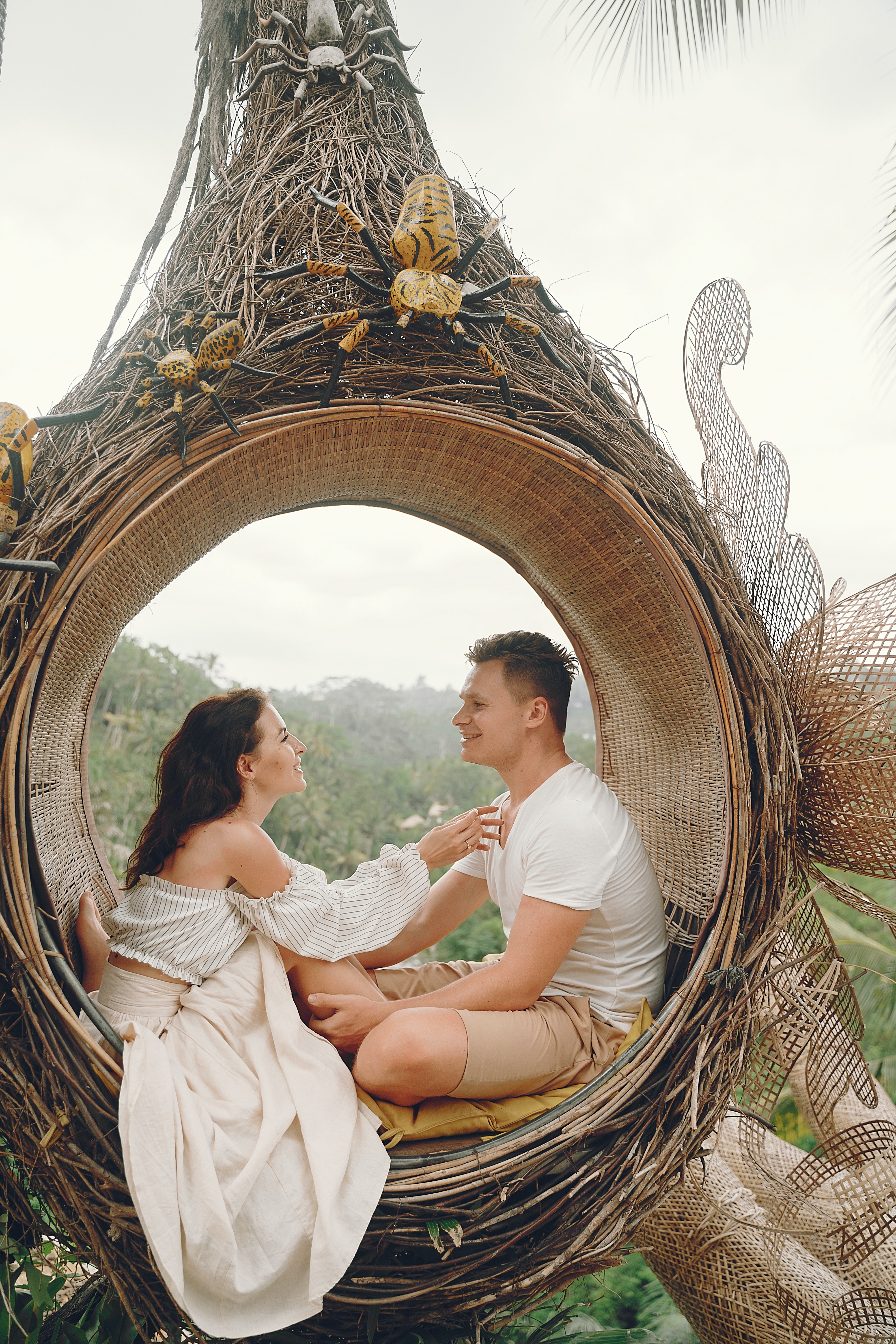 couple in a big nest swing wearing white